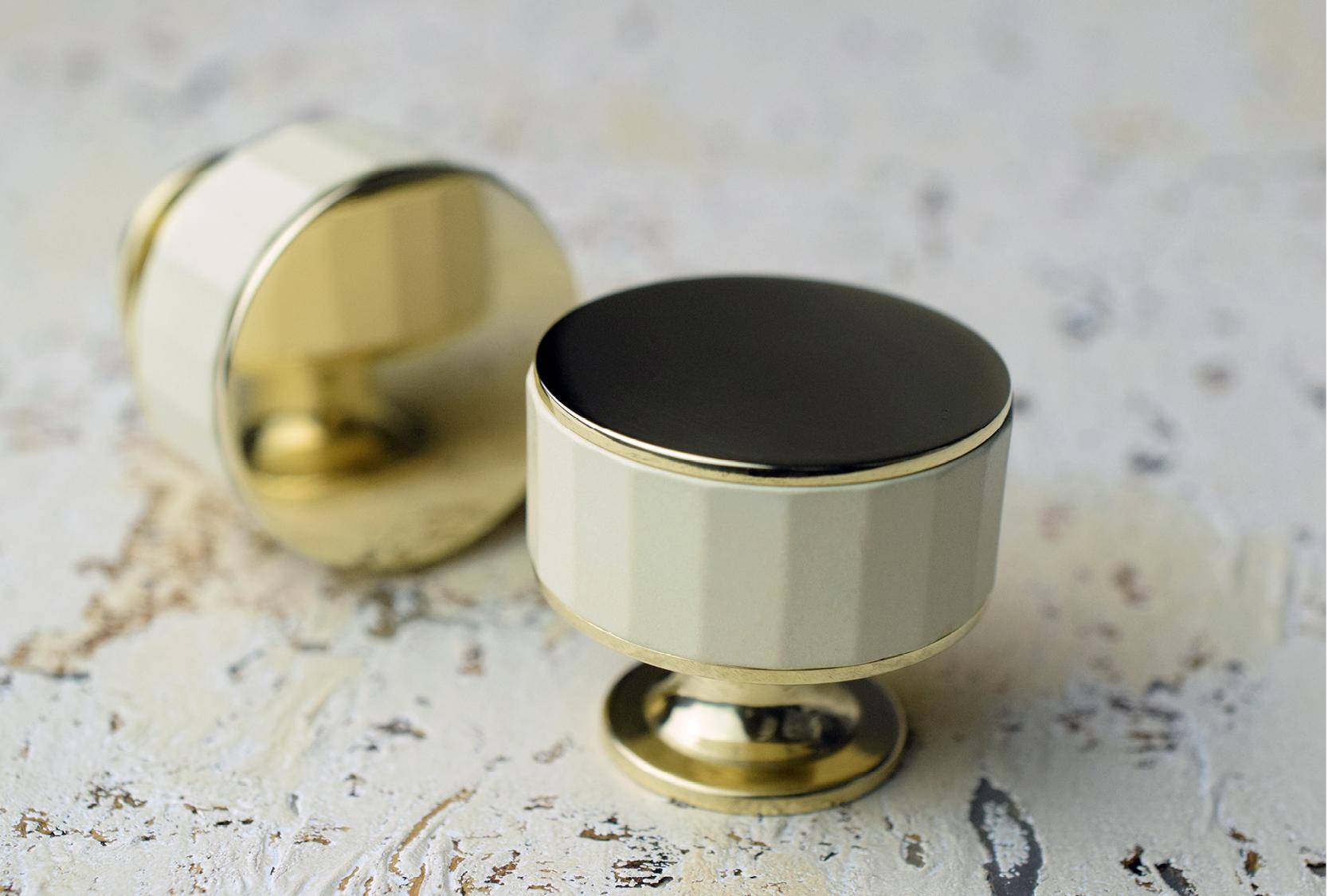 Image of two custom stacked faceted cabinet knob. The cabinet knob has a custom cream grip with a polished brass metal finish