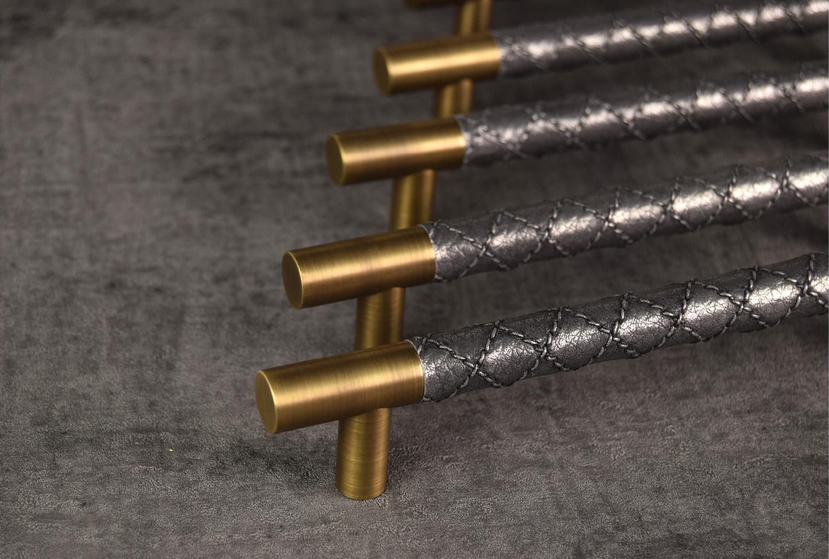 Image displays four custom chesterfield design pull handles. The pull handle grip is finished in Alupewt with a polished brass metal finish.