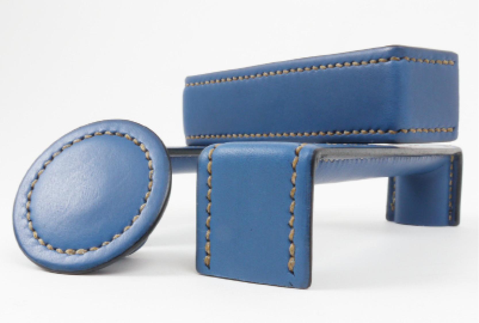Image displays Turnstyle Designs Savile range. The range includes the bench and button designs Both designs are finished in a custom aqua blue leather, with a natural stitch.
