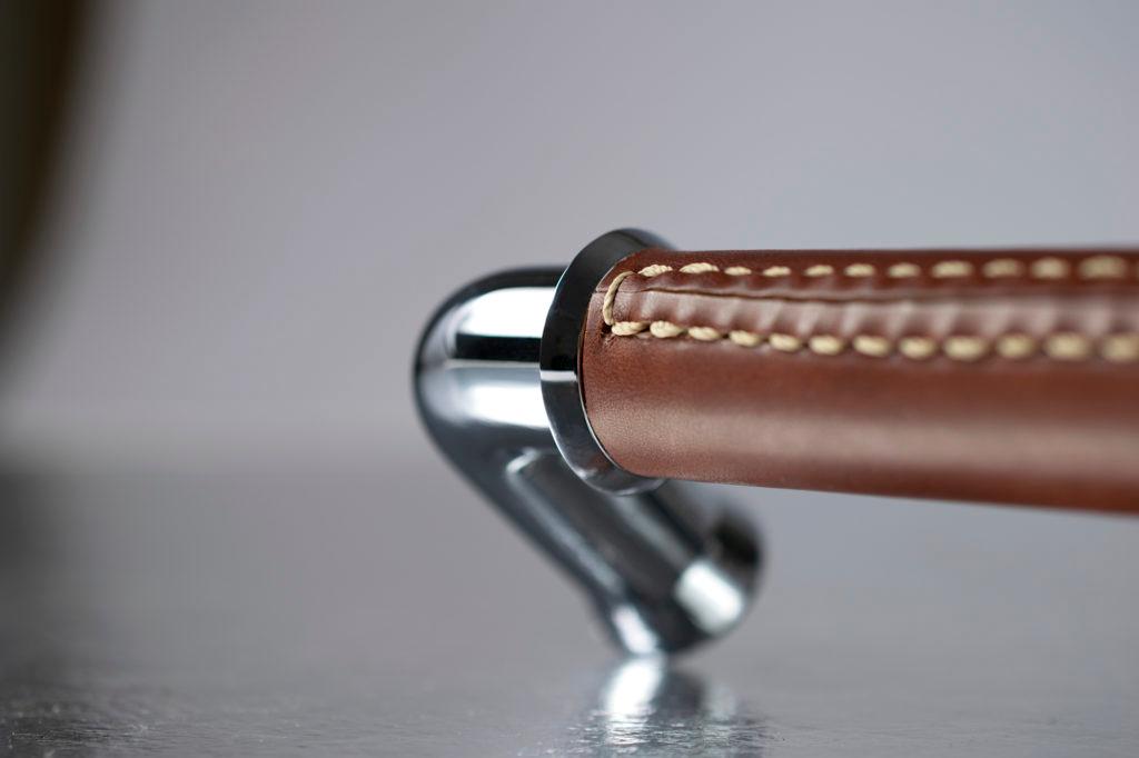 Rich Italian chestnut leather with hand stitched natural thread has been used on this large Pipe shaped door pull. The brass finish is Bright chrome.
