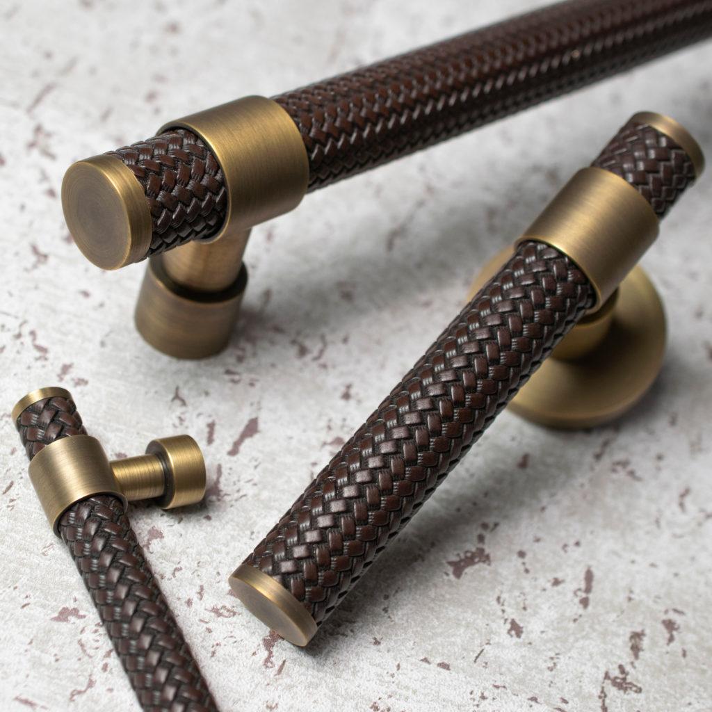 Part of the Woven stepped Amalfine collection, shown here is the door lever, door pull and cabinet handle in Cocoa with Fine Antique Brass.