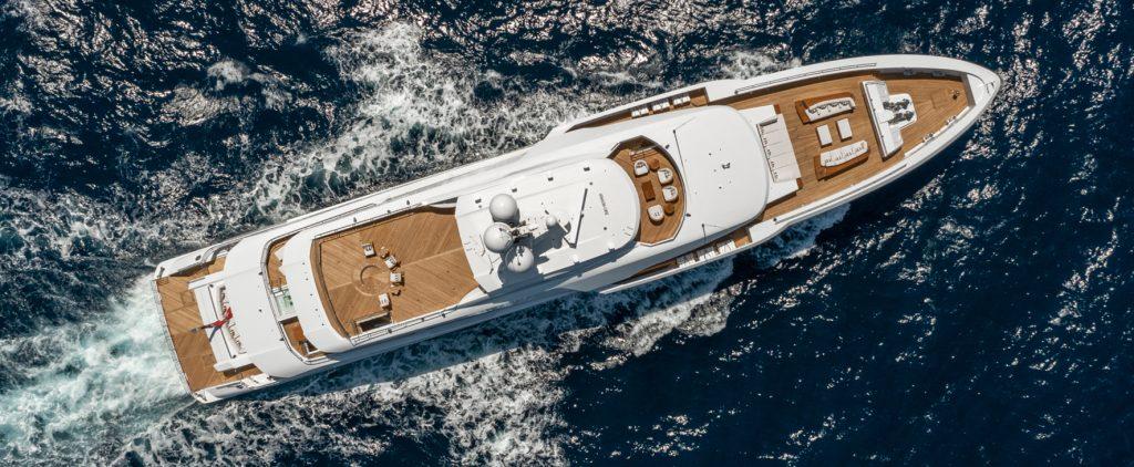 Motor yacht Lusine making way along the open ocean. This is an exterior shot taken from a birds eye view angle.