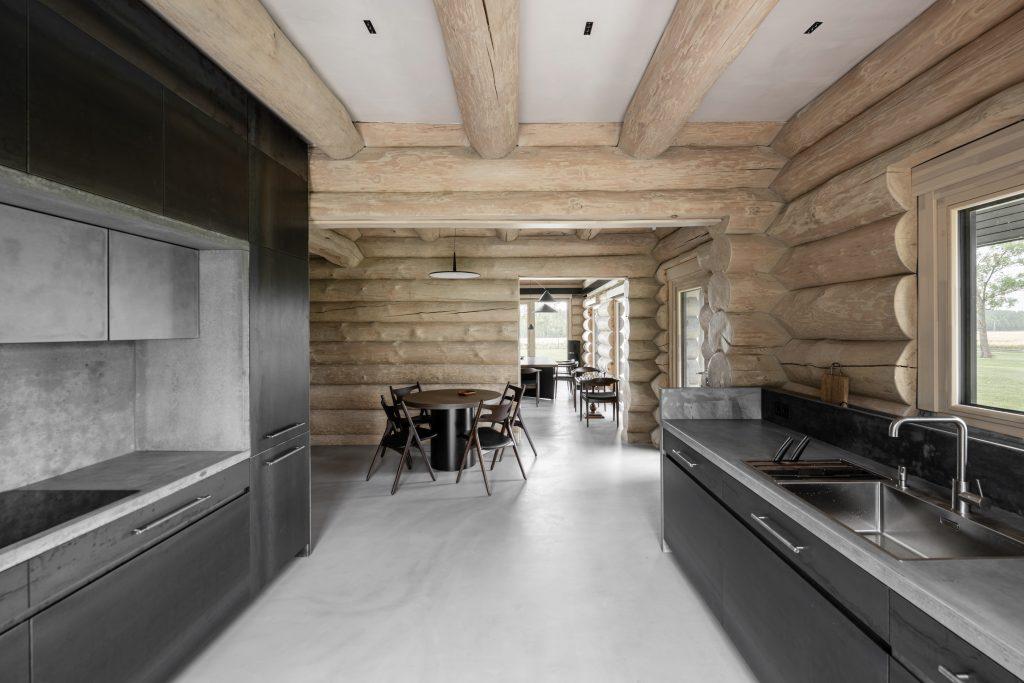 The walls in this image have been created used large wooden logs. Design with a clean sleek stainless steel and concrete kitchen, the brief was to design a space for a keen hunter. A space for not only functionality but also relaxing after a long day on the hunt.