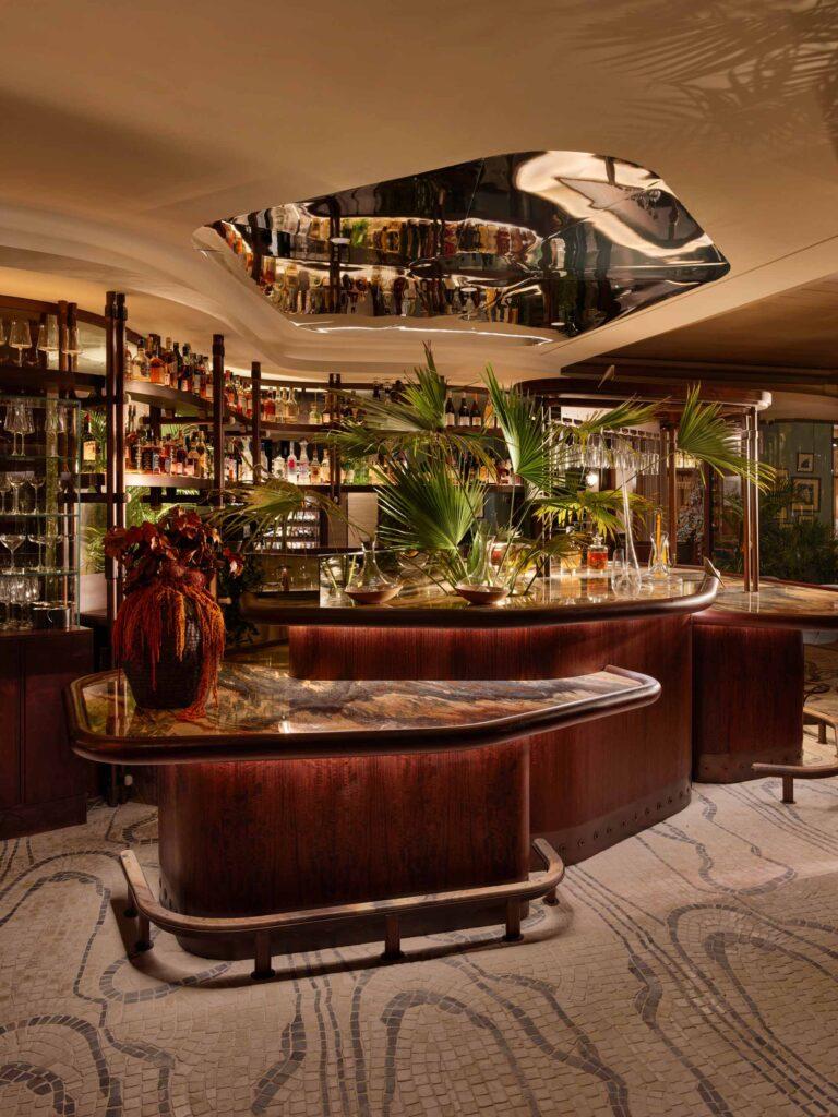 The bar area of a luxury fine dining restaurant. The dark wood and natural textures are inspired by the outside world.